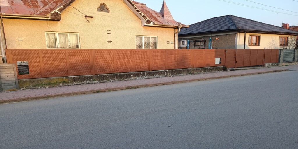 Košické Olšany községben egy átfogó projektet valósítottunk meg, amely egy egyedi gyártású kétszárnyú kapuból állt teljes automatizálással, rozsdamentes acél vasalattal ellátott kis kapuból videó kaputelefonnal, valamint több mint 10 méter hosszú elülső kerítésből